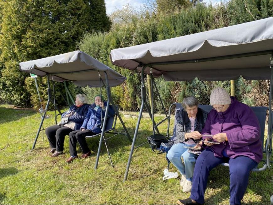 seniorzy siedzą na huśtawkach 